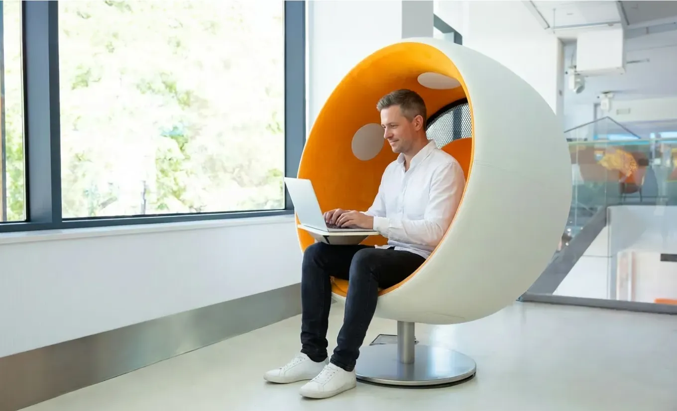 A StorePulse team member working on a laptop in a quiet office pod